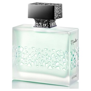 Bottiglia di profumo M. Micallef, design elegante con intagli geometrici, tappo nero, vetro trasparente.