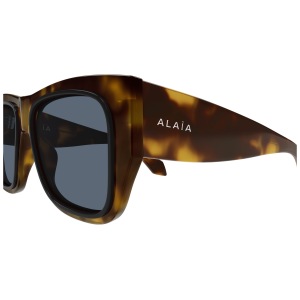 Occhiali Alaïa, montatura spessa tartarugata marrone, forma squadrata, logo bianco su asta laterale.